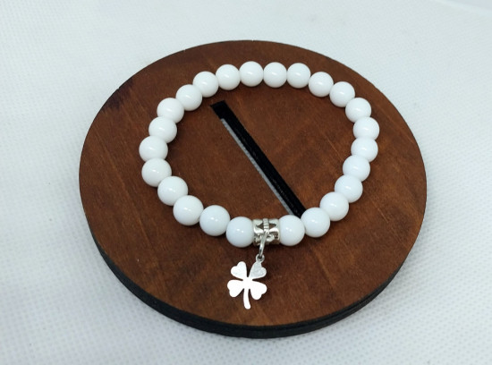 Браслет ручной работы из акриловых бусин белого цвета с подвеской  форме клевера